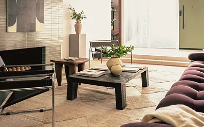 Ladera Heights sunken living room with tubular steel and leather chairs, an aubergine sofa and a tiled fireplace, staged by Nesting Dolls Design