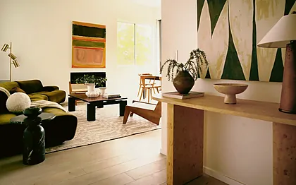 Silver Lake open plan seen from a burl entry console through an olive velvet sofa to the dining area, staged by Nesting Dolls Design
