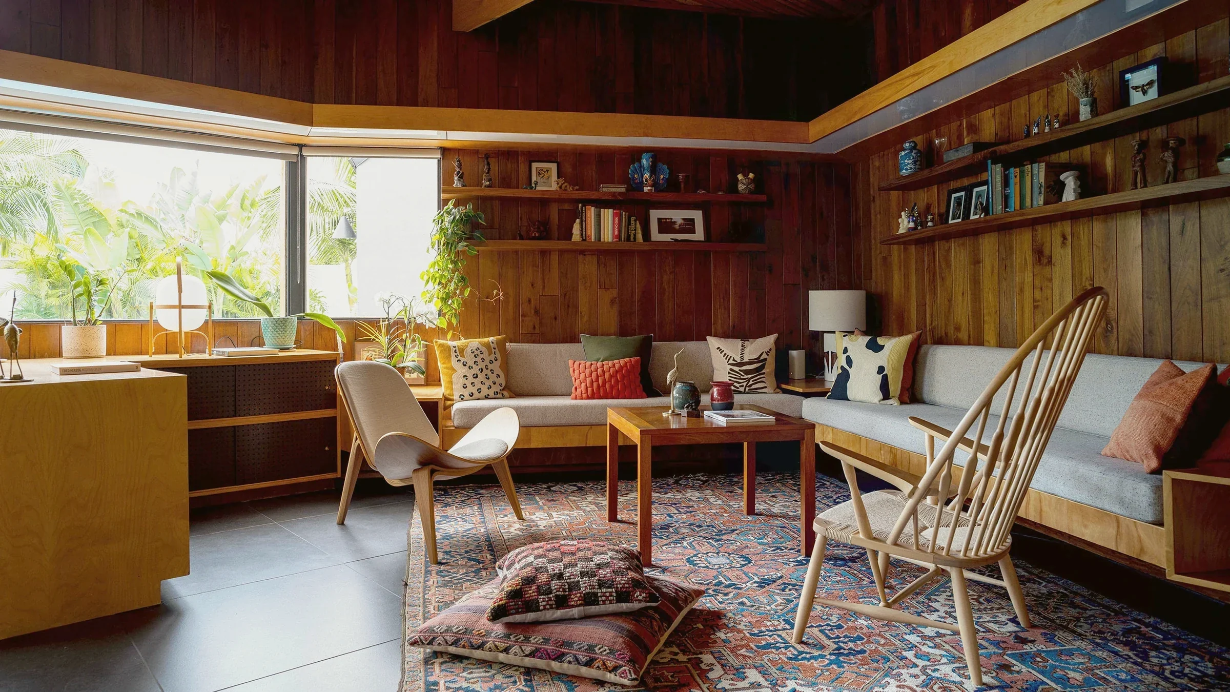 Original walnut-panelled walls, beechwood built-in bench seating and a Wegner shell chair in the 1954 Robinson Residence, Jefferson Park, styled by Nesting Dolls Design