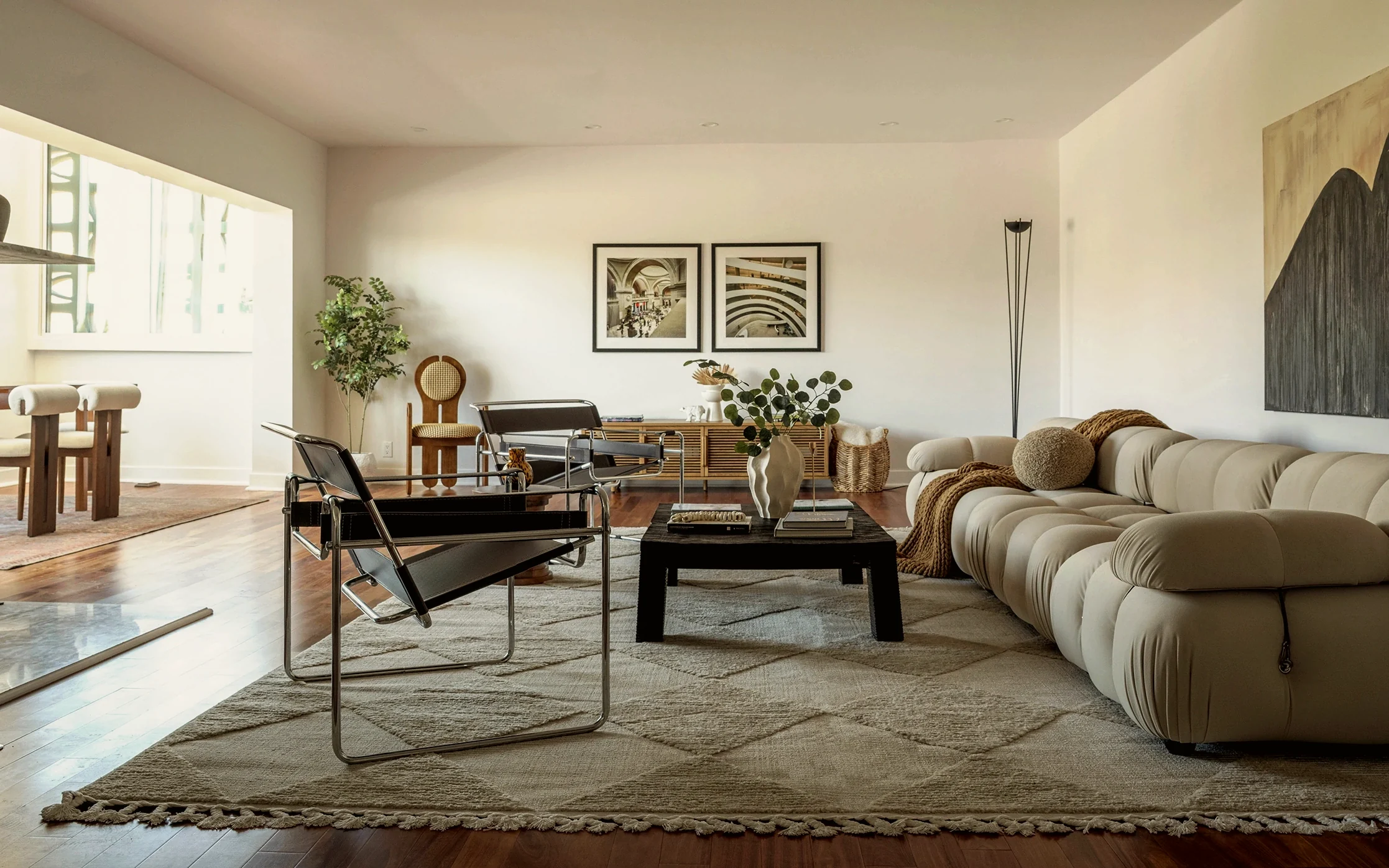 Larchmont penthouse living room with a cream modular sofa, Wassily chairs, a blackened oak coffee table and a diamond-pattern wool rug, staged by Nesting Dolls Design