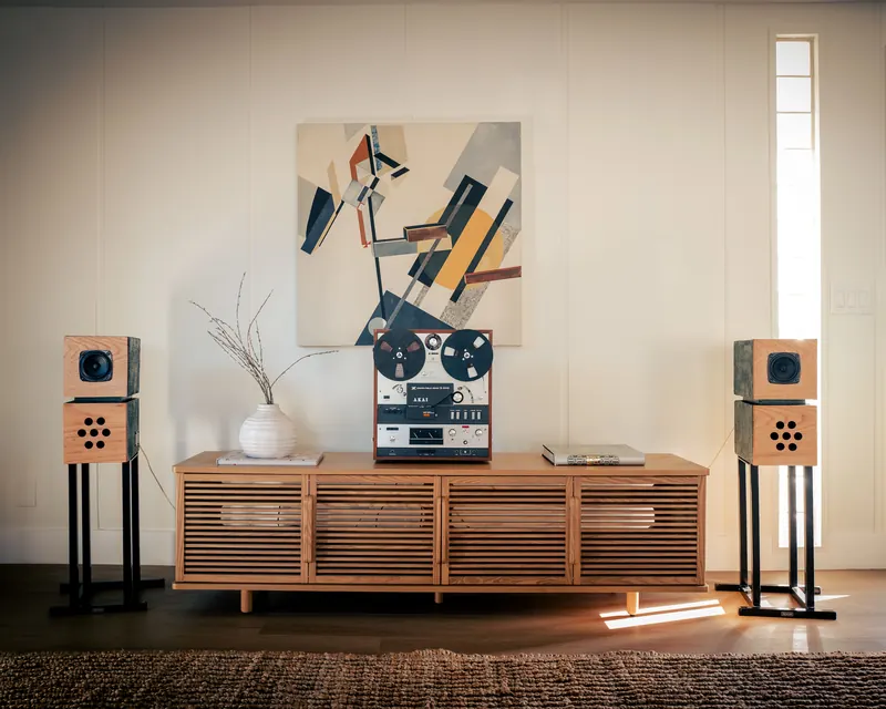 Ladera Heights listening room with standmount speakers flanking a slatted oak credenza and reel-to-reel deck, staged by Nesting Dolls Design