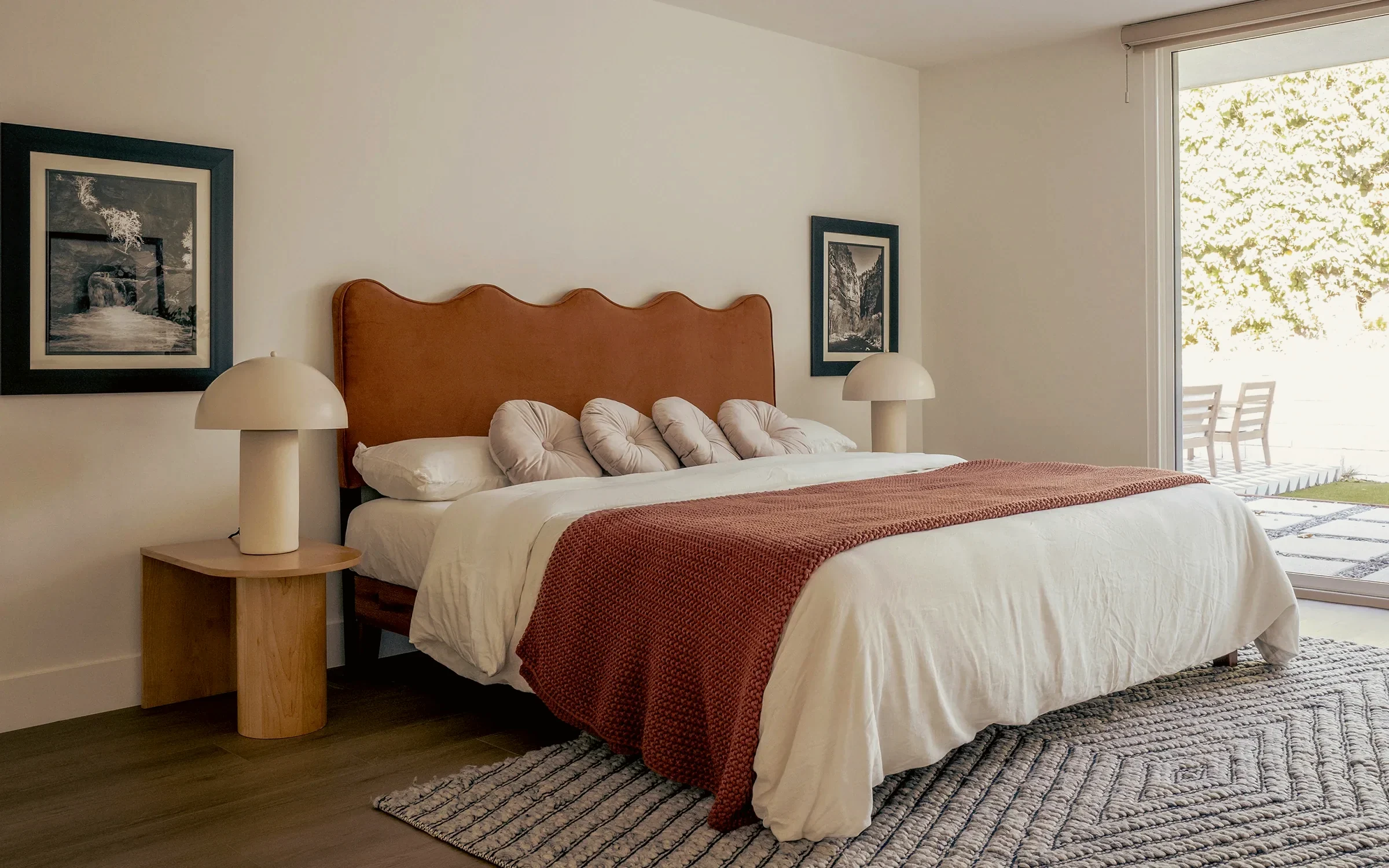 Ladera Heights bedroom with a rust velvet scalloped headboard and paired dome lamps, staged by Nesting Dolls Design