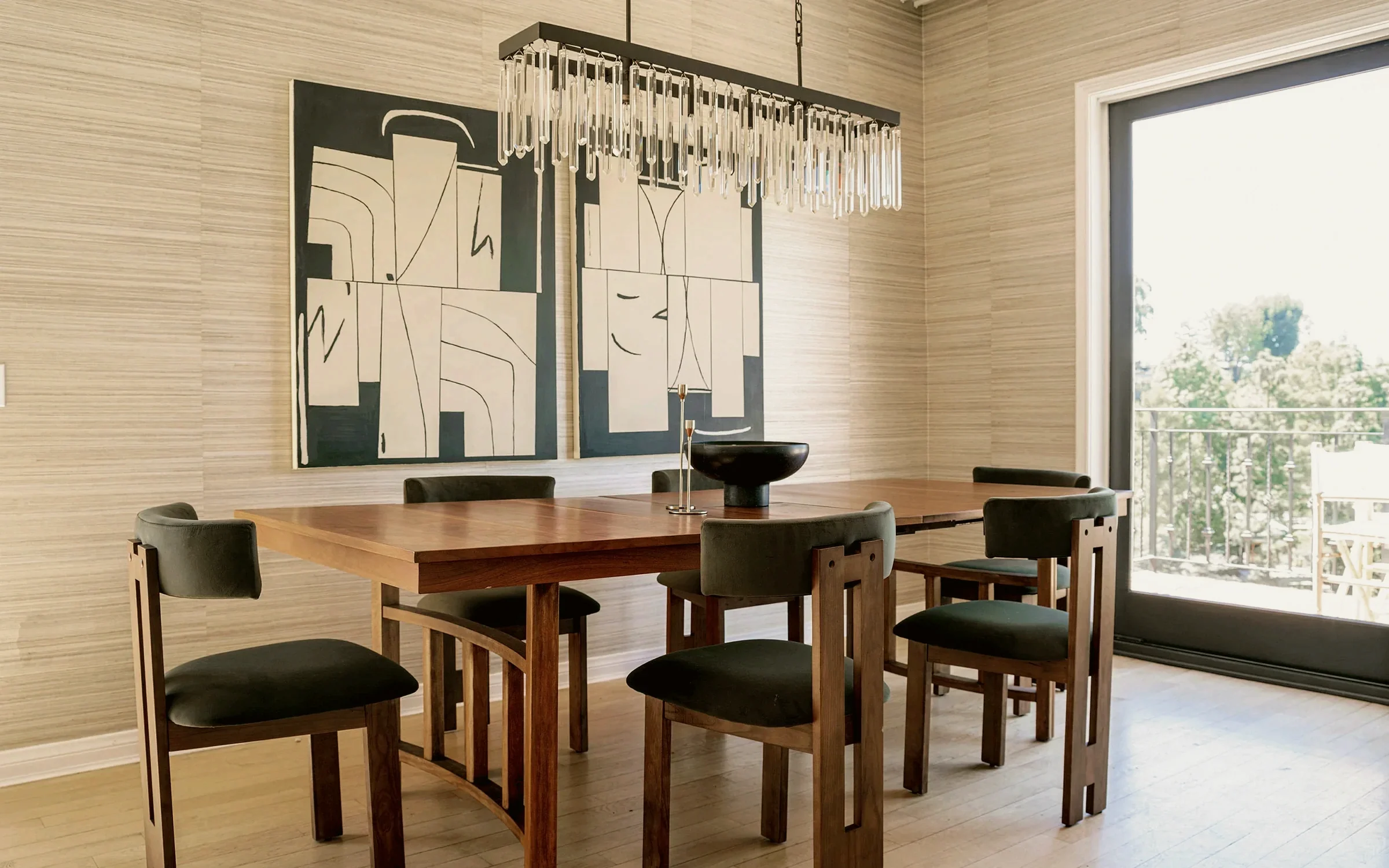Laurel Canyon dining room with a walnut table, olive velvet chairs and a black and white diptych on grasscloth walls, staged by Nesting Dolls Design