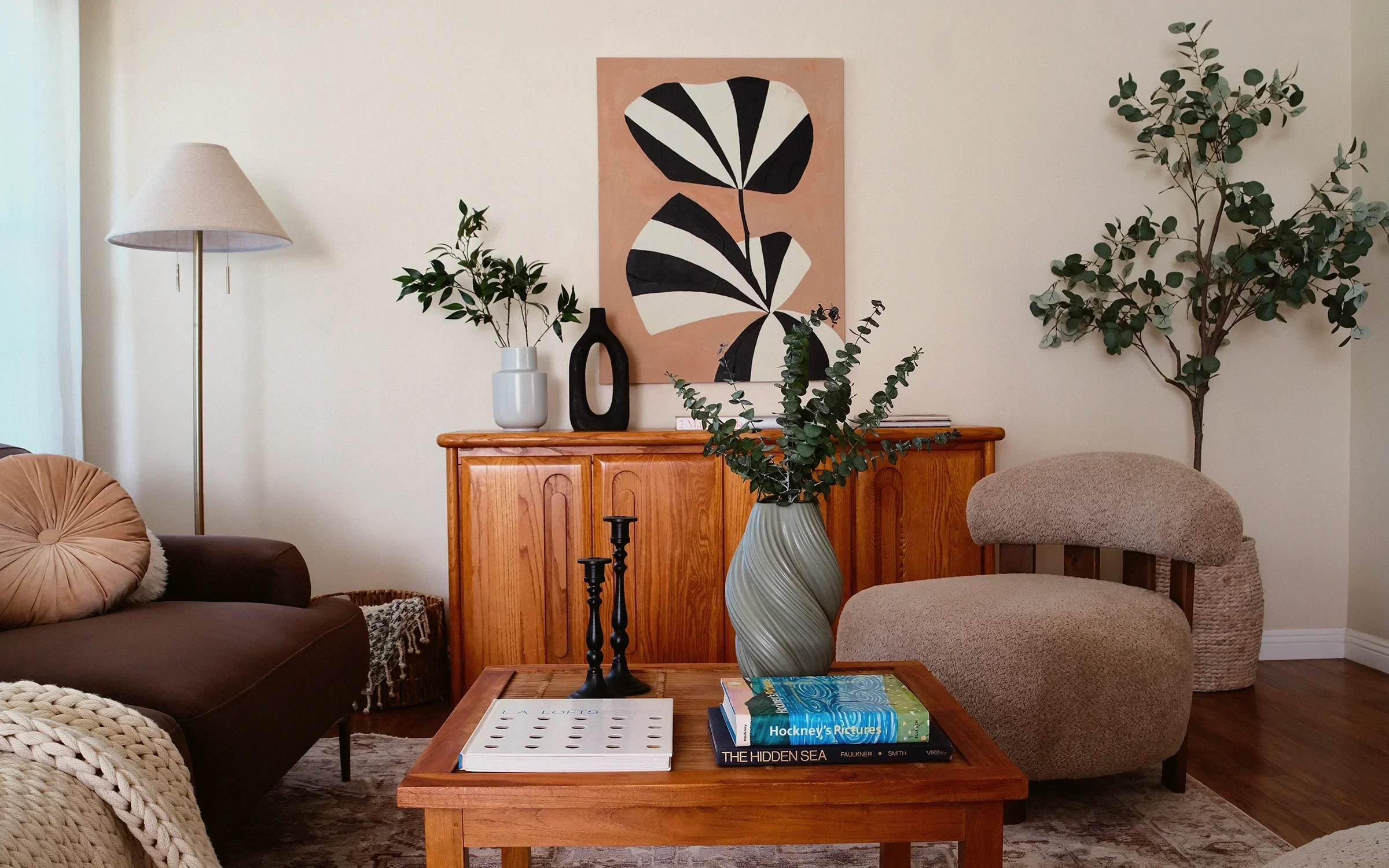 North Hollywood living room with a vintage oak credenza, a terracotta canvas and a shearling armchair, staged by Nesting Dolls Design