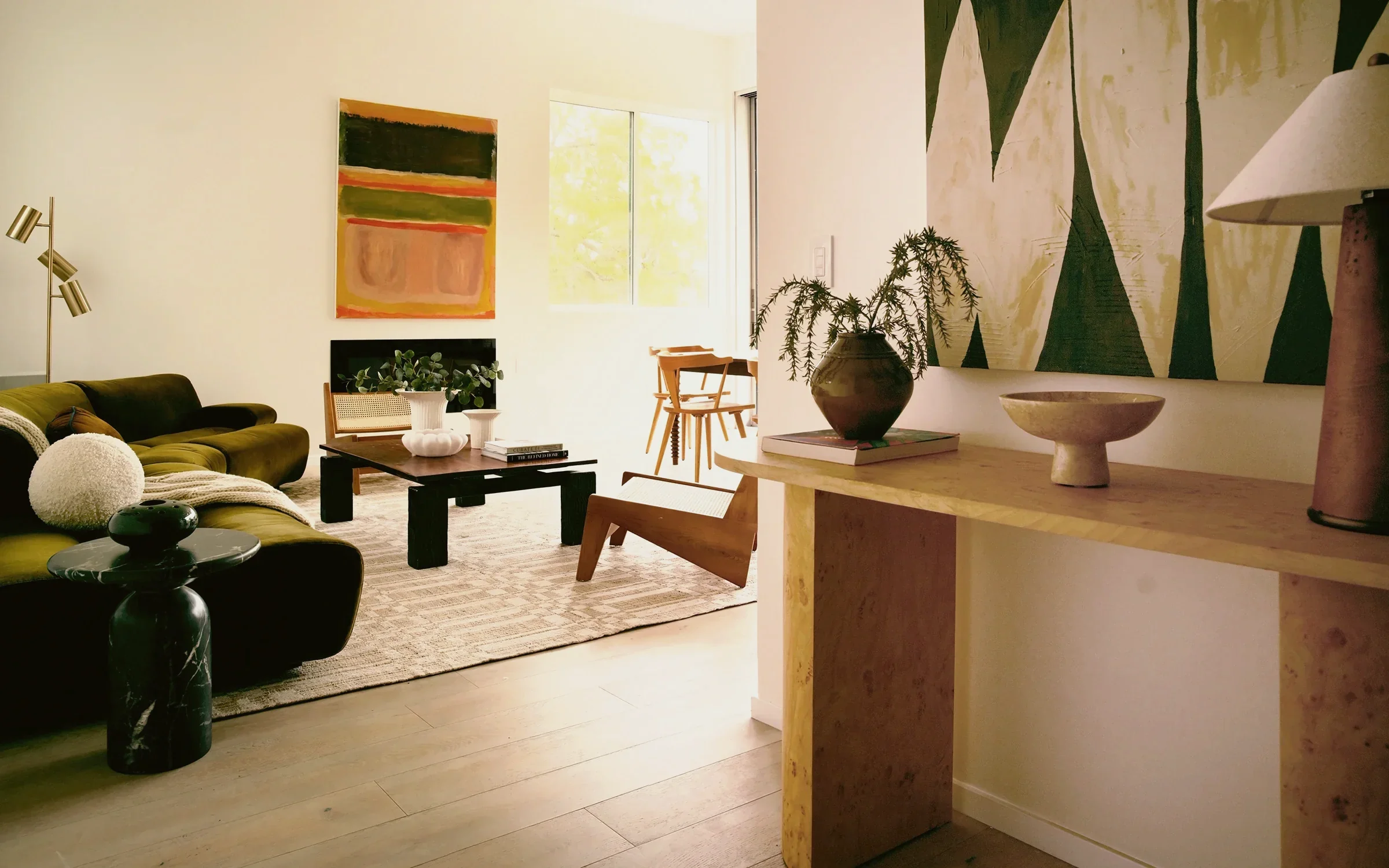 Silver Lake open plan seen from a burl entry console through an olive velvet sofa to the dining area, staged by Nesting Dolls Design